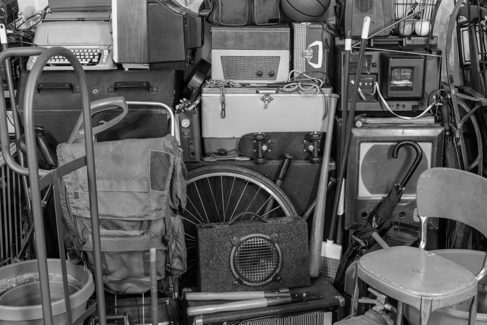 Vintage attic storage area with old tools, gardening, music and sports equipment in black and white.