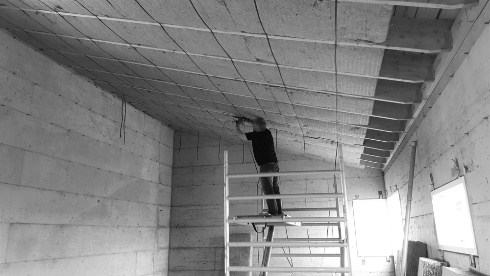 Man puting insulation on the inside of the roof